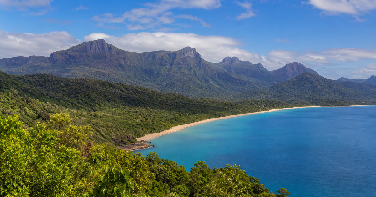 Panoramic view of Hinchinbrook Island, traditionally known as Munamudanamy, showing rainforest-covered mountains and coastal waters.